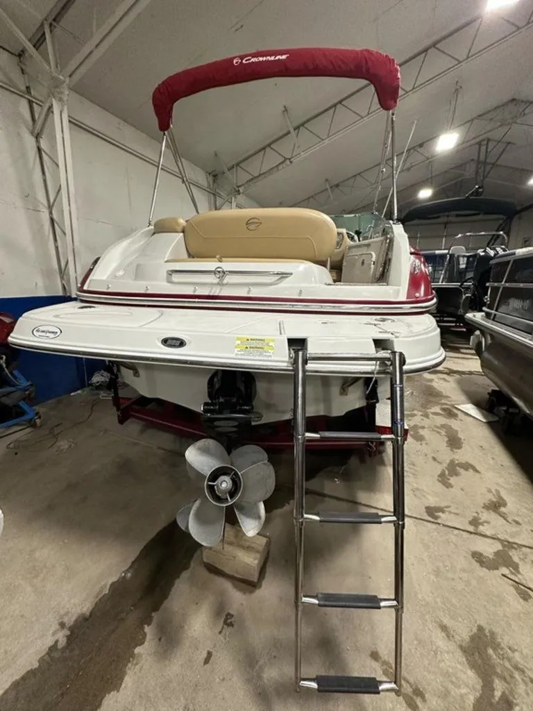Slide: The Image of 2015 Crownline 236 SC boat with ladder and propeller in indoor storage. - 25