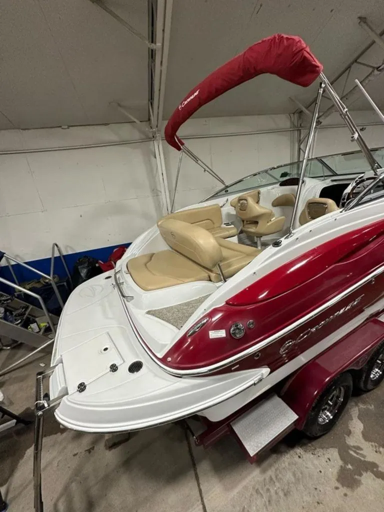 Slide: The Image of 2015 Crownline 236 SC boat with red and white exterior, beige seating, and covered canopy. - 4