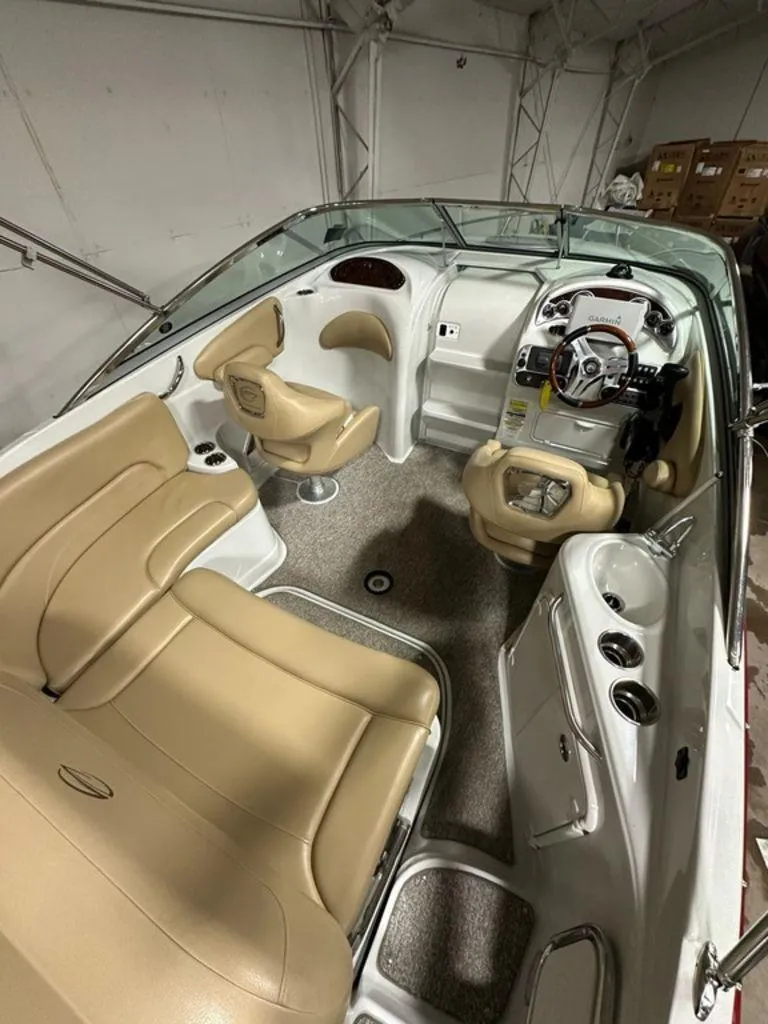 Slide: The Image of 2015 Crownline 236 SC boat interior with beige seating and modern dashboard. - 6