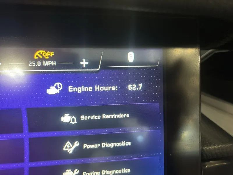 Slide: The Image of Display screen of 2022 Nautique G25 Paragon showing 62.7 engine hours and 25 MPH speed. - 11