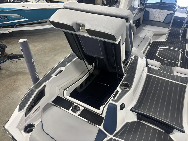 Slide: The Image of 2022 Nautique G25 Paragon boat interior with open storage compartment and seating. - 13