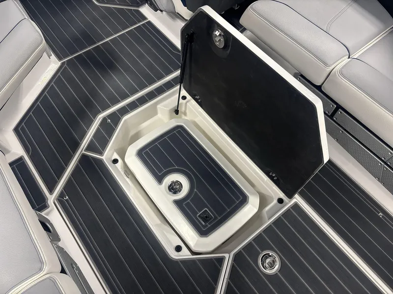 Slide: The Image of 2022 Nautique G25 Paragon boat interior with open storage compartment and cushioned seating. - 15