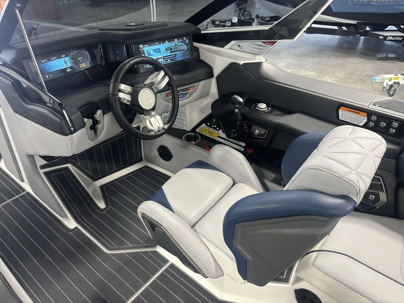 Slide: The Image of Interior of 2022 Nautique G25 Paragon boat, featuring modern dashboard and luxurious seating. - 9