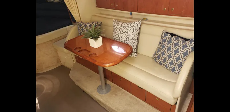 Slide: The Image of 1999 Sea Ray 330 Sundancer interior with cozy seating and wooden table. - 13