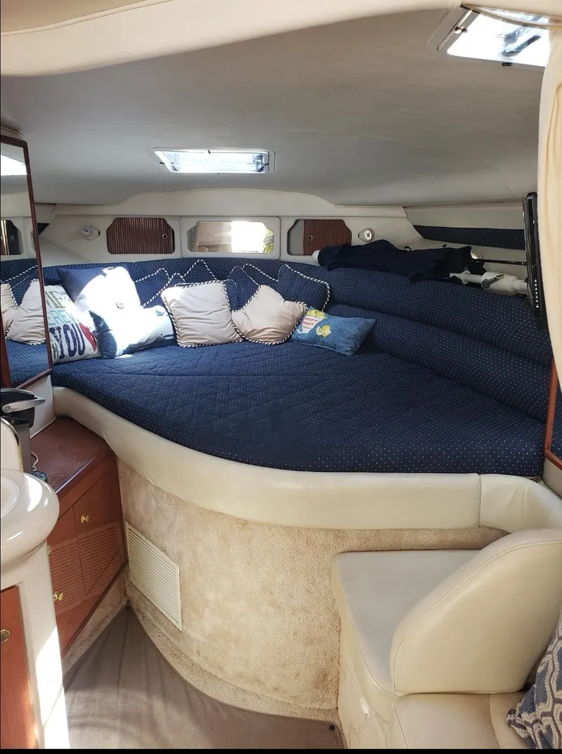 Slide: The Image of 1999 Sea Ray 330 Sundancer cabin interior with cozy bedding and seating. - 14