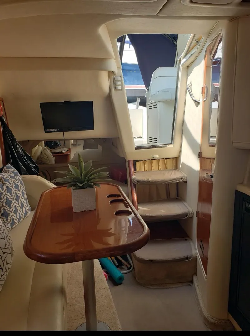 Slide: The Image of Interior of 1999 Sea Ray 330 Sundancer with cozy seating and wooden table. - 15