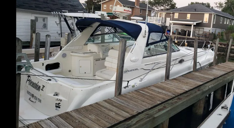 Slide: The Image of 1999 Sea Ray 330 Sundancer docked, featuring sleek design and spacious seating. - 3