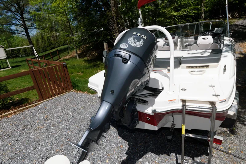 Slide: The Image of 2020 Chaparral 19 SSi OB boat with outboard motor, parked on gravel driveway. - 12