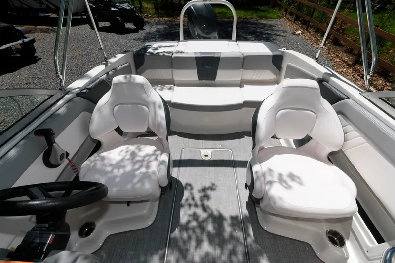 Slide: The Image of 2020 Chaparral 19 SSi OB boat interior with white seating and steering wheel. - 4