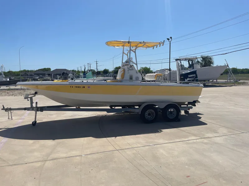 Slide: The Image of 2003 Baystealth 2230 boat on trailer, yellow and white, parked outdoors. - 1