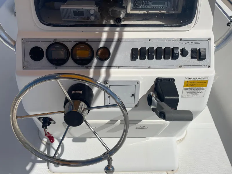 Slide: The Image of 2003 Baystealth 2230 boat dashboard with steering wheel and control panel. - 14