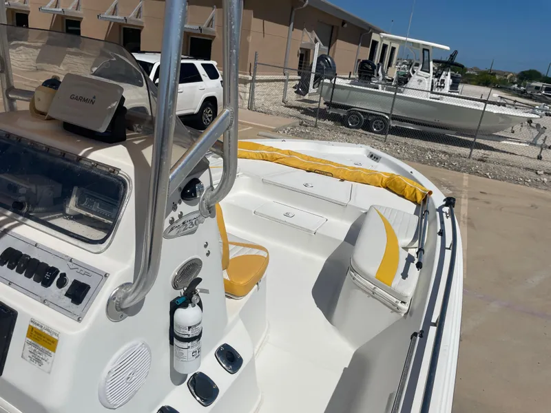 Slide: The Image of 2003 Baystealth 2230 boat with Garmin GPS, yellow seating, and white exterior in a marina. - 16