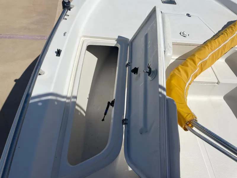 Slide: The Image of Open storage compartment on a 2003 Baystealth 2230 boat with yellow cover. - 22