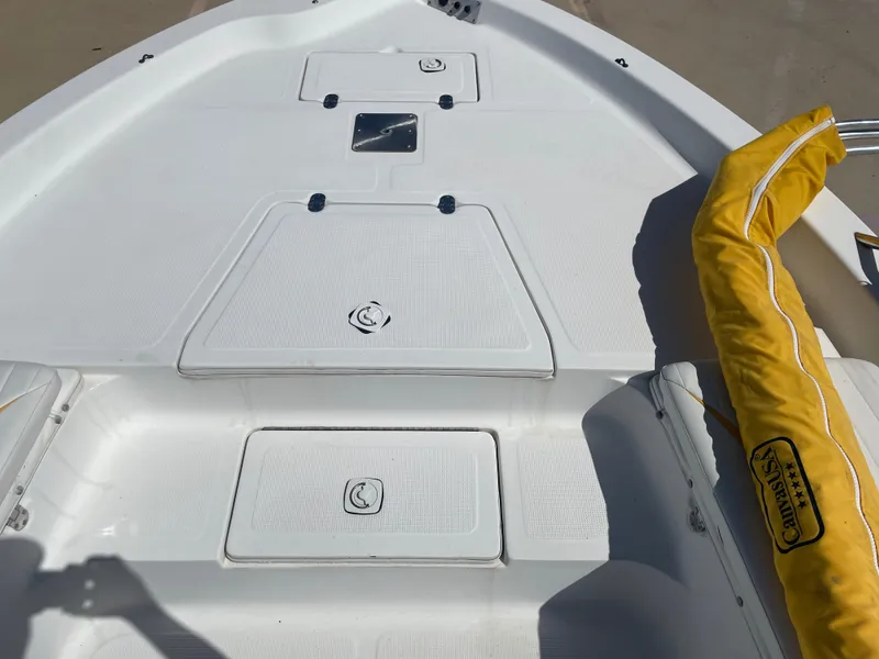 Slide: The Image of 2003 Baystealth 2230 boat deck with storage compartments and yellow cover. - 23
