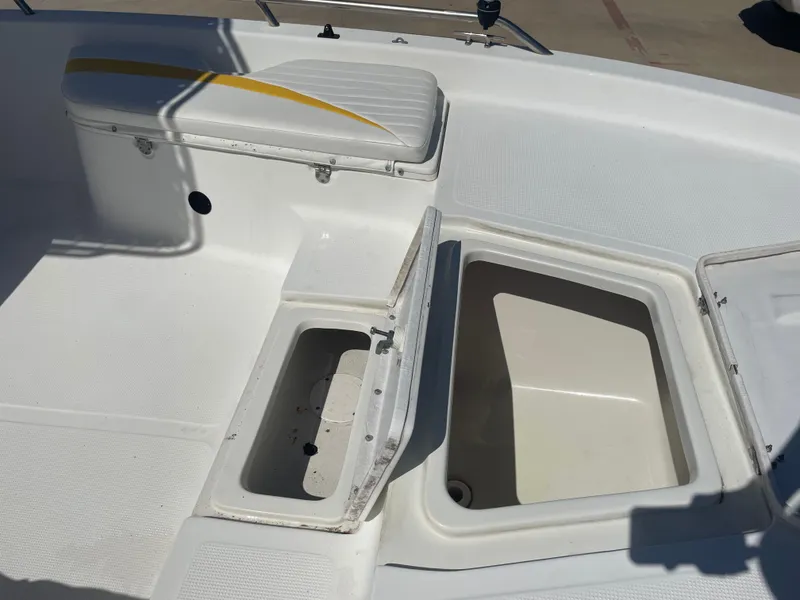 Slide: The Image of 2003 Baystealth 2230 boat interior with open storage compartments and cushioned seating. - 24