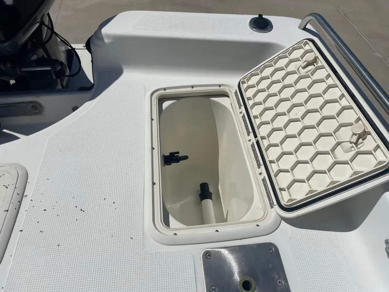 Slide: The Image of Open storage compartment on a 2003 Baystealth 2230 boat, featuring a hexagonal lid design. - 8