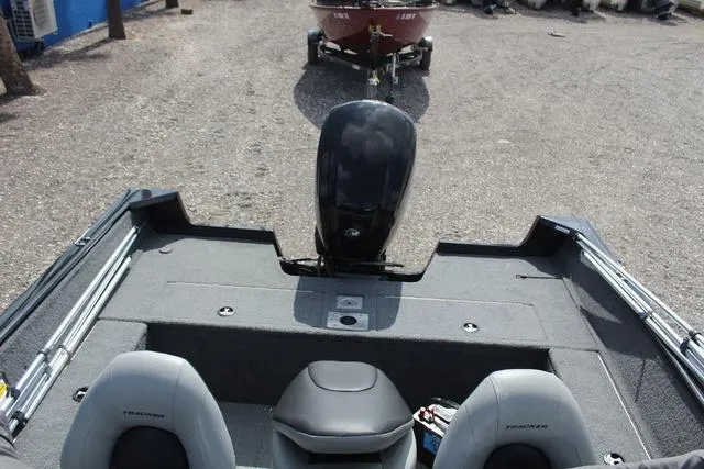 Slide: The Image of 2019 Tracker Pro Guide V-165 WT boat interior with motor, gray seating, and storage compartments. - 16