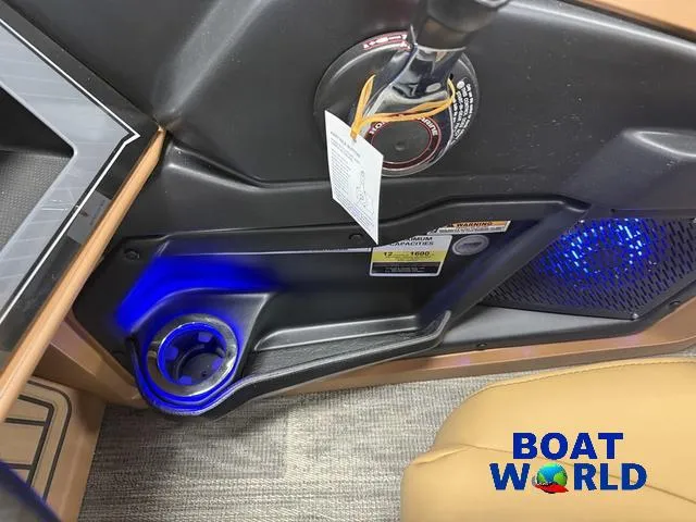 Slide: The Image of Control panel of 2025 Tahoe Cascade 2385 Tritoon with illuminated cup holder and Boat World logo. - 18