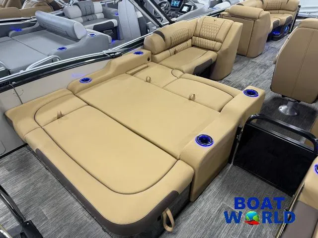 Slide: The Image of Luxurious interior of 2025 Tahoe Cascade 2385 Swingback Tritoon with plush seating and cup holders. - 22