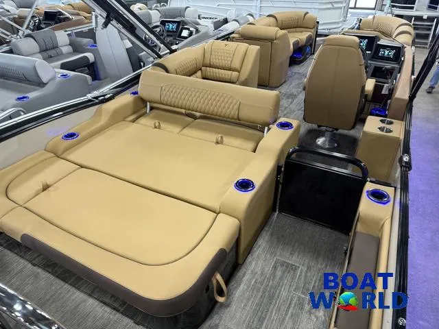 Slide: The Image of 2025 Tahoe Cascade 2385 Swingback Tritoon interior with luxurious tan seating and modern controls. - 23