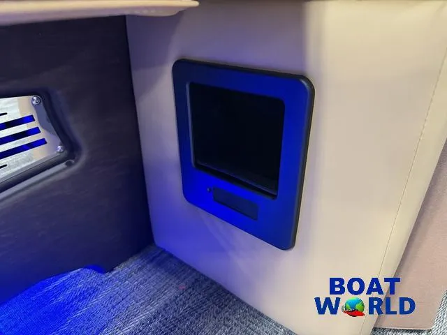 Slide: The Image of 2025 Tahoe Cascade 2385 Tritoon interior with blue LED lighting and control panel. - 33