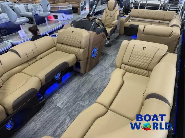 Slide: The Image of 2025 Tahoe Cascade 2385 Tritoon interior with luxurious tan seating and blue LED lighting. - 34
