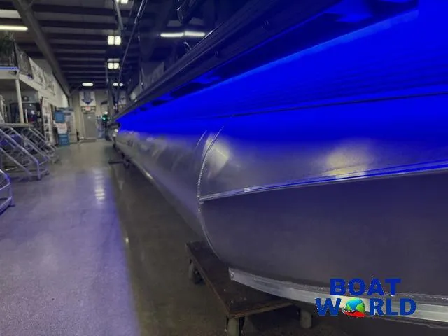 Slide: The Image of 2025 Tahoe Cascade 2385 Tritoon with blue LED lights in showroom. - 38