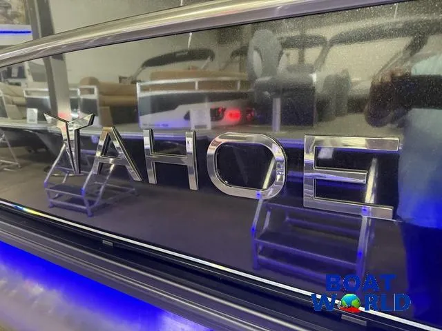 Slide: The Image of 2025 Tahoe Cascade 2385 Swingback Tritoon logo with blue LED lighting at Boat World. - 40
