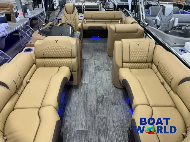 Slide: The Image of Luxurious interior of 2025 Tahoe Cascade 2385 Swingback Tritoon with tan seating and blue lighting. - 8