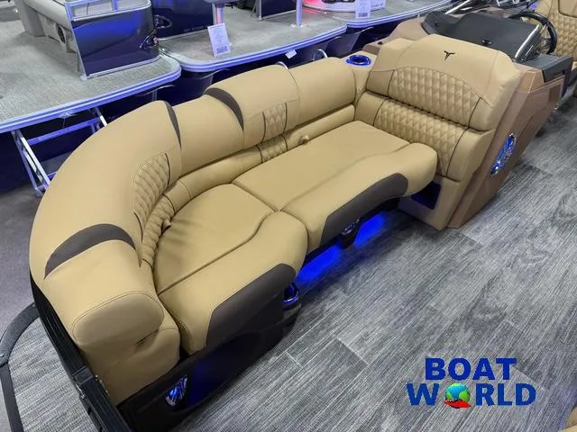 Slide: The Image of 2025 Tahoe Cascade 2385 Tritoon with luxurious tan seating at Boat World showroom. - 9