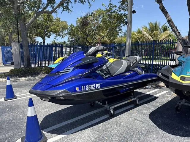 Slide: The Image of 2014 Yamaha WaveRunner FX HO in blue, parked outdoors with trees and cones nearby. - 4