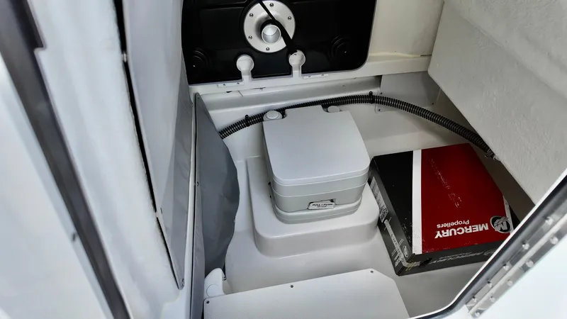 Slide: The Image of 2025 Bayliner Trophy 24 CC interior with portable toilet and storage compartment. - 11