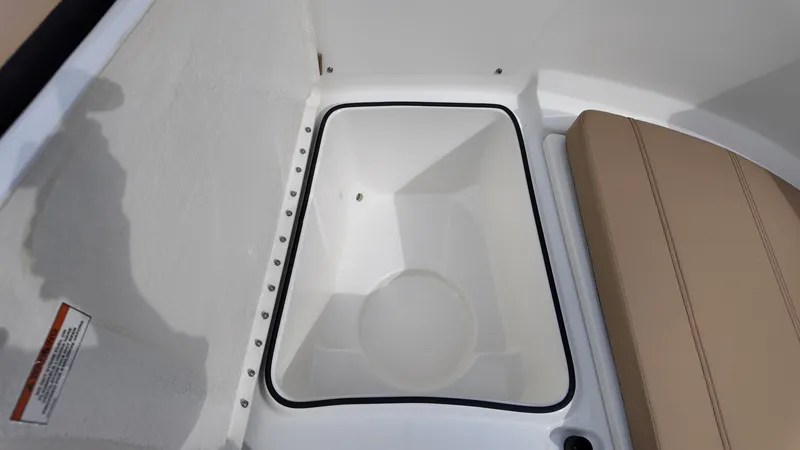 Slide: The Image of 2025 Bayliner Trophy 24 CC boat storage compartment with beige seating. - 18