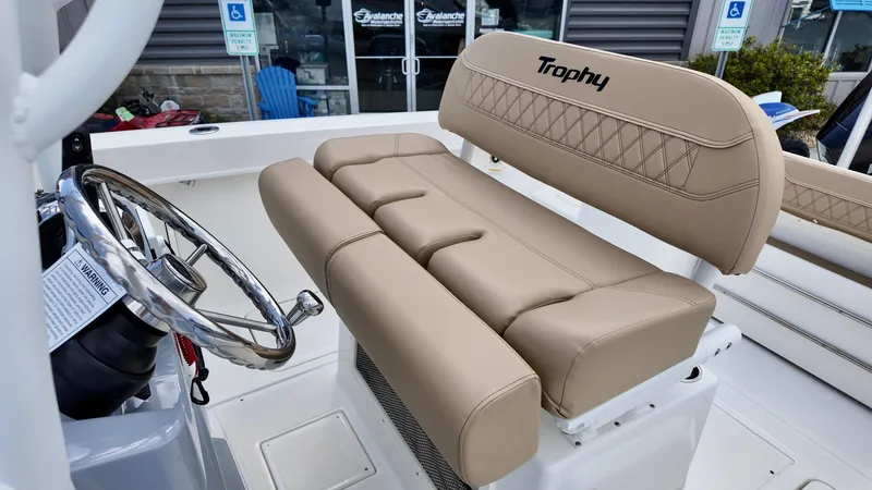 Slide: The Image of 2025 Bayliner Trophy 24 CC boat interior with beige seating and steering wheel. - 7