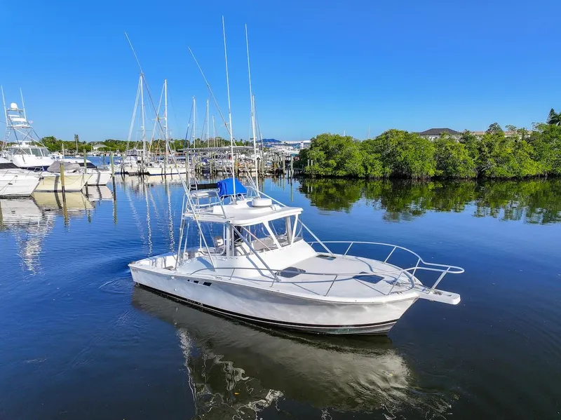 Slide: The Image of 1997 Luhrs Tournament 320 Open boat docked in a serene marina setting. - 1