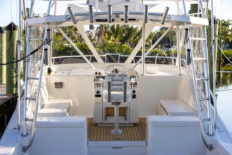 Slide: The Image of 1997 Luhrs Tournament 320 Open boat interior with helm, seating, and fishing rod holders. - 13