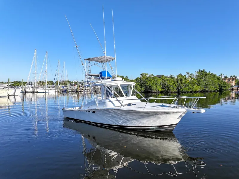 Slide: The Image of 1997 Luhrs Tournament 320 Open boat on calm water, clear sky background. - 2