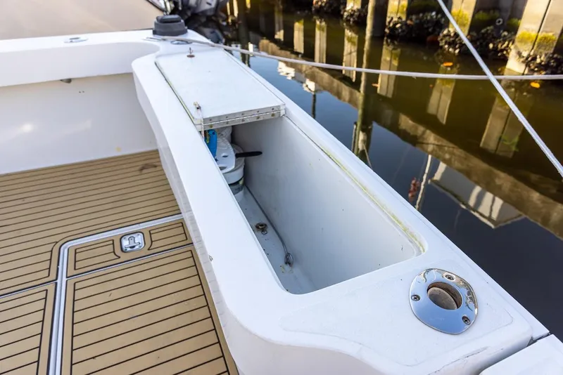 Slide: The Image of 1997 Luhrs Tournament 320 Open boat deck with storage compartment and teak flooring. - 23