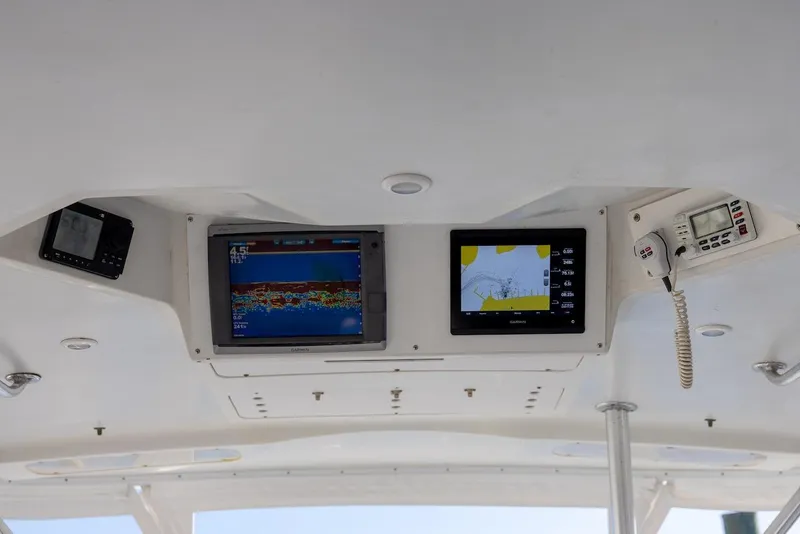 Slide: The Image of 1997 Luhrs Tournament 320 Open boat dashboard with navigation screens and radio equipment. - 25