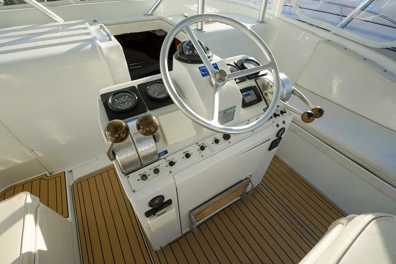 Slide: The Image of 1997 Luhrs Tournament 320 Open helm with steering wheel and controls on teak deck. - 35