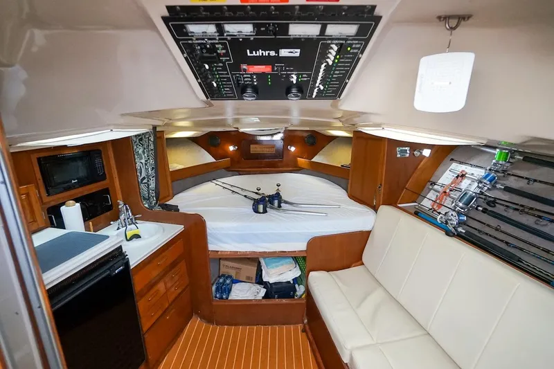 Slide: The Image of Interior of a 1997 Luhrs Tournament 320 Open boat, featuring cozy seating and fishing gear. - 39