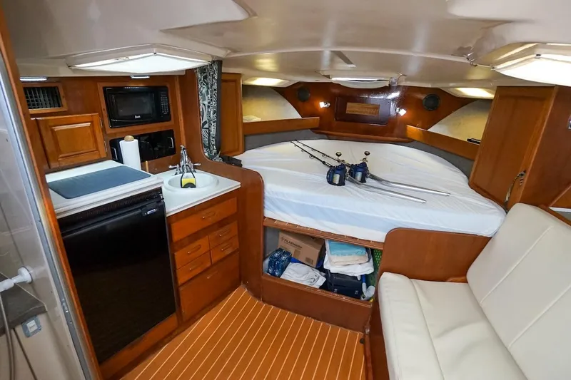 Slide: The Image of 1997 Luhrs Tournament 320 Open cabin interior with kitchenette, bed, and seating area. - 40