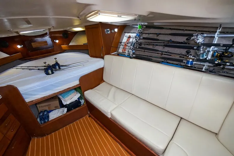 Slide: The Image of 1997 Luhrs Tournament 320 Open cabin with fishing rods, bed, and storage. - 41