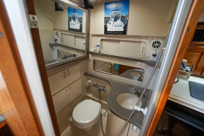 Slide: The Image of 1997 Luhrs Tournament 320 Open boat bathroom with sink, toilet, and mirror. - 42