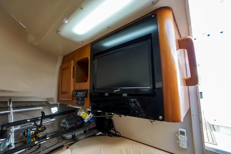 Slide: The Image of 1997 Luhrs Tournament 320 Open cabin interior with TV and fishing gear storage. - 46