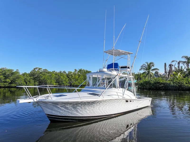 Slide: The Image of 1997 Luhrs Tournament 320 Open boat on calm water, surrounded by lush greenery. - 6
