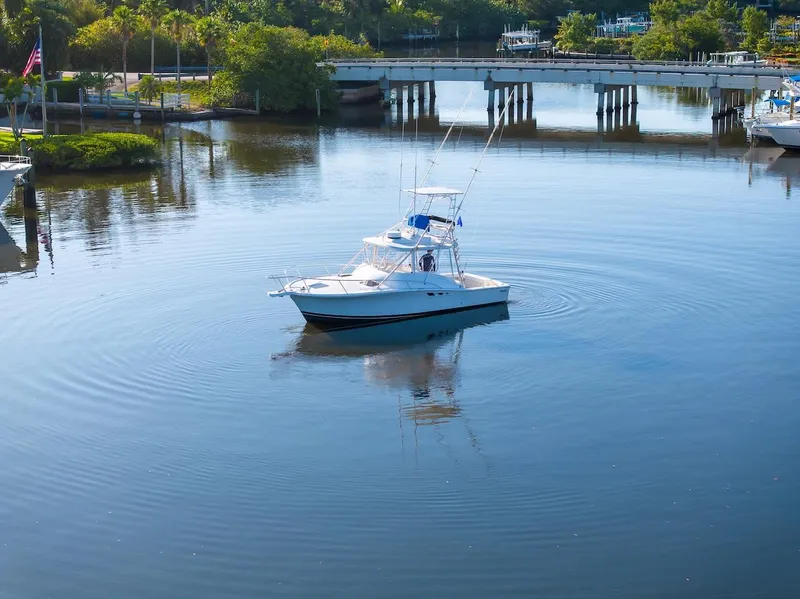 Slide: The Image of 1997 Luhrs Tournament 320 Open boat on calm water near a bridge. - 8