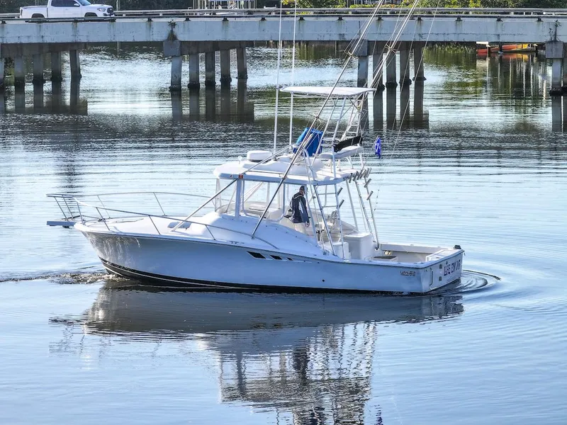 Slide: The Image of 1997 Luhrs Tournament 320 Open boat on calm water near a bridge. - 9