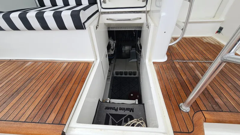 Slide: The Image of Engine compartment of 2000 Ocean Yachts 70 Super Sport with teak flooring and striped seating. - 17