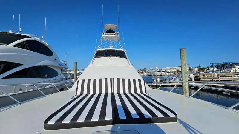Slide: The Image of Ocean Yachts 70 Super Sport 2000 with striped sunbed, docked at marina under clear blue sky. - 19